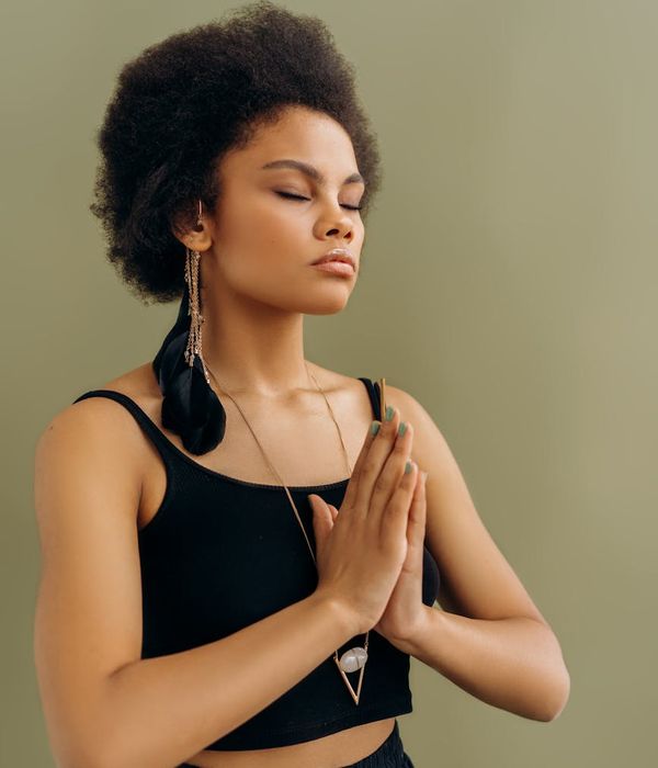 Woman in a peaceful meditation pose in a serene setting.
